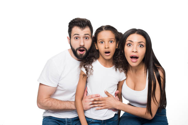 istock Surprised multiethnic family sitting together and looking at camera isolated on white 804937204