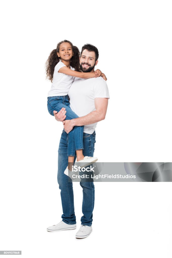 Padre feliz llevando a adorable hijita y sonriendo a cámara - Foto de stock de Padre libre de derechos