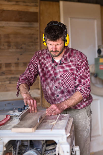 istock Male Carpenter cutting plank by circular saw 804940616
