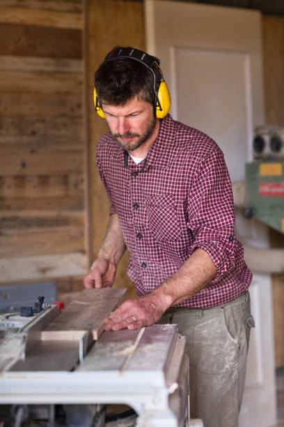 istock Male Carpenter cutting plank by circular saw 804940934