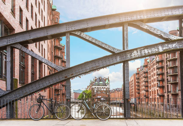 bicicletas aparcadas contra la barandilla de hierro en un puente en el antiguo barrio de almacén speicherstadt en hamburgo, alemania - architecture blue bridge iron fotografías e imágenes de stock