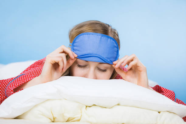 istock Young woman wearing sleeping eye band in bed 804952770