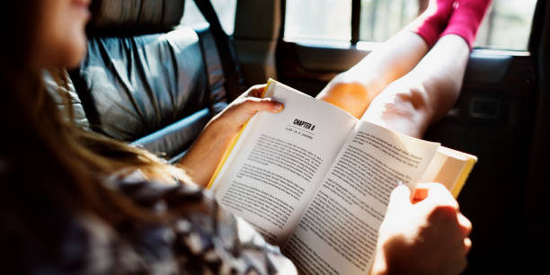 istock Girl Reading Book Inside Car Concept 804955360