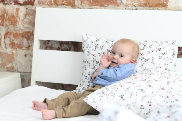 istock A cute boy is lying on the parent's bed and is looking at the camera 804955806