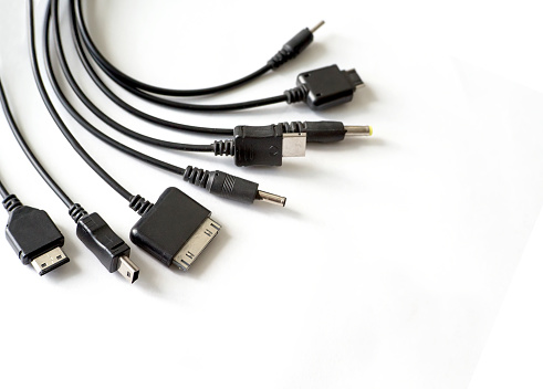 different types of chargers for phones and tablets on white background