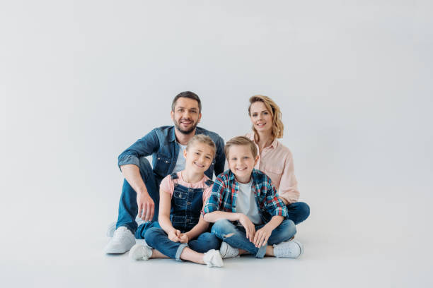 istock smiling family looking at camera while sitting together on the floor 805000970