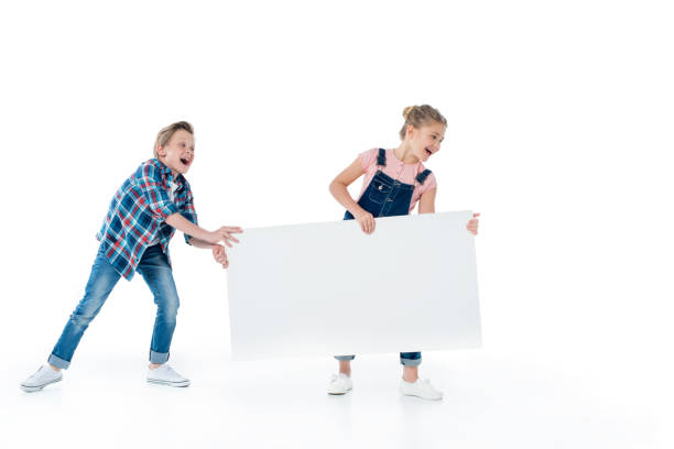 istock Cheerful cute kids having fun with blank placard isolated on white 805001400