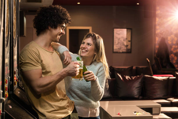 junge brautpaar toasten mit bier in einem pub. - beer dartboard sport pub stock-fotos und bilder