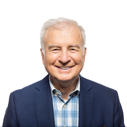 Portrait of happy senior businessman smiling against white background
