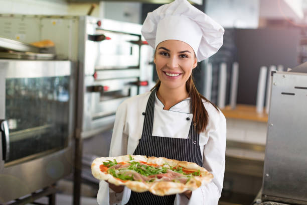 istock Smiling chef holding fresh pizza in kitchen 805019960