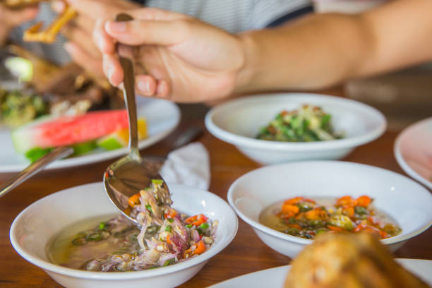 Close up adult women taking sambal matah, the balinese raw sambal. Its chopped chilli with peel shallot and garlic, lemongrass and coconut oil.