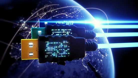 An abstract 3D render of a frontal view on three USB cables in space. The USB connectors are positioned over a defocused night Earth globe and feature LCD screens with binary numbers.


