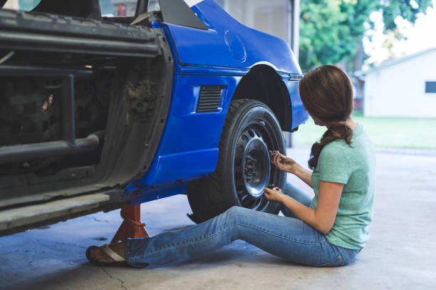 istock Mechanic works on car in her home garage 805054504