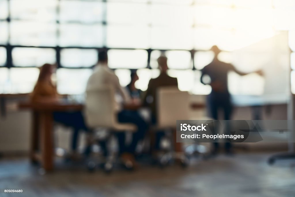 Meeting in session Full length bokeh shot of a group of corporate businesspeople meeting in the boardroom Defocused Stock Photo
