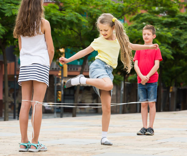 istock Happy kids playing with chinese jumping rope 805069196