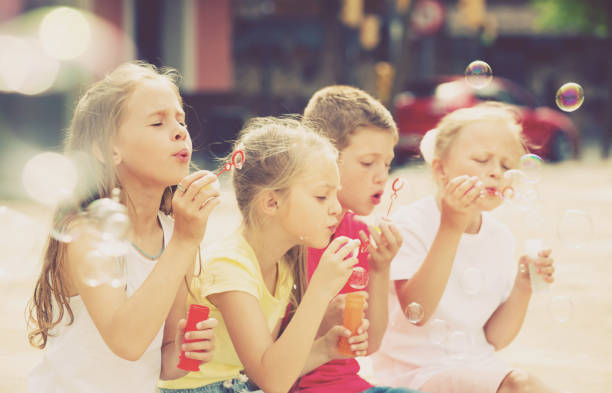 istock children blowing bubbles outdoors 805069402