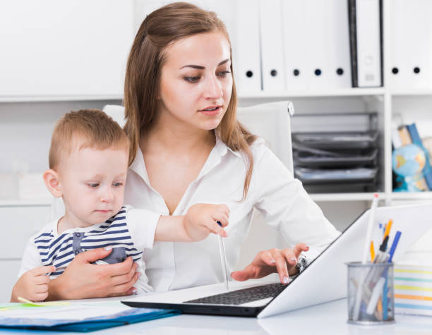istock Mother with child is working behind laptop 805073702