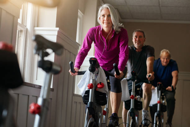 Spin together to win together Shot of a group of seniors having a exercising class at the gym cardiovascular exercise stock pictures, royalty-free photos & images