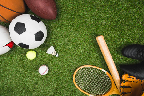 다양 한 스포츠 공, 야구 방망이 글러브, 녹색 잔디밭에서 배드민턴 라켓의 상위 뷰 - recreational sports 뉴스 사진 이미지