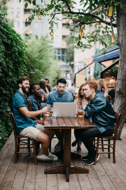 istock Multi-ethnic group of people using laptop at the pub 805125068
