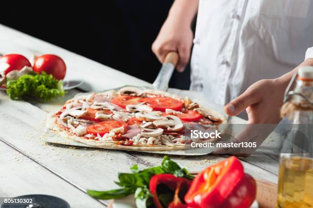 Closeup Hand Of Chef Baker In White Uniform Making Pizza At Kitchen Stock Photo - Download Image Now