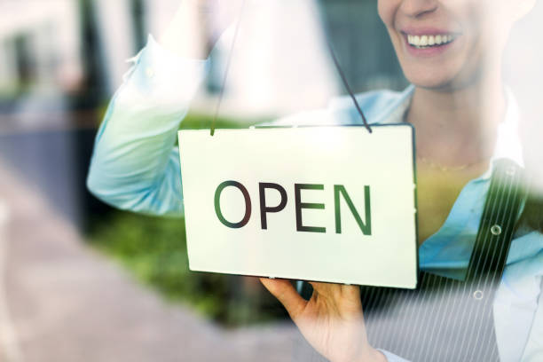 istock Woman holding open sign in cafe 805151112