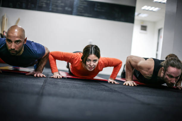 istock Young people  doing push-ups in the gym. People workout i  gym. 805170852