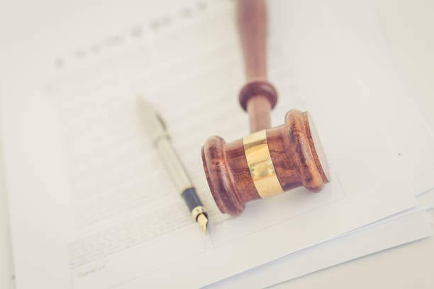 istock WOODEN JUDGE GAVEL WITH CONTRACT DOCUMENT AND PEN CONCEPT 805172348
