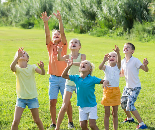 istock friendly kids jumping together in park on summer 805208108