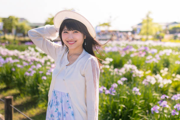日本アイリス フィールドで幸せな若い女の肖像 - iris single flower flower outdoors ストックフォトと画像