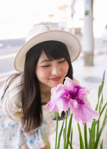 Young woman closely looking at Japanese iris