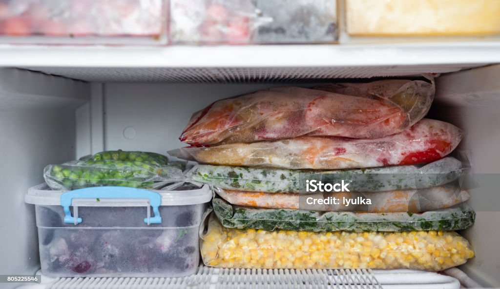 Frozen berries and vegetables Frozen berries and vegetables in bags in freezer close up Freezer Stock Photo