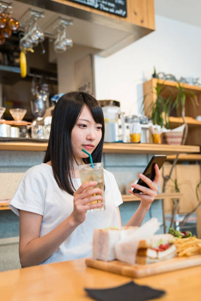 istock Woman enjoying lunch in a cafe while using a smartphone 805234444
