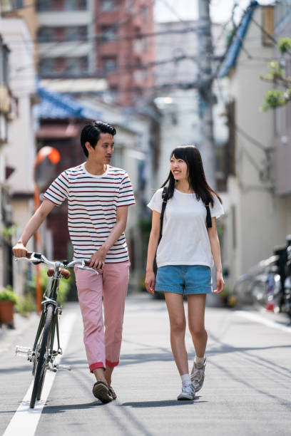 istock Man walking with a woman and pushing his bicycle 805248480