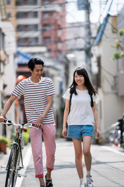 istock Man walking with a woman and pushing his bicycle 805248482