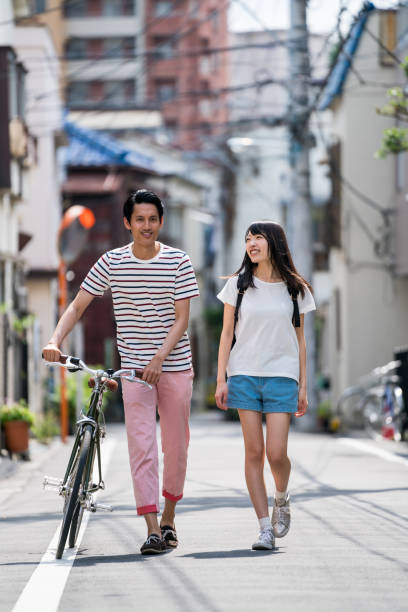 istock Man walking with a woman and pushing his bicycle 805248790