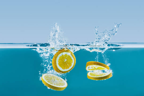 istock side view of fresh lemon slices falling into water with splashes 805259120