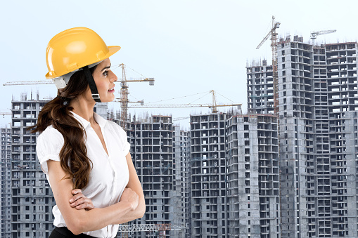 Portrait of female architect looking at building construction site