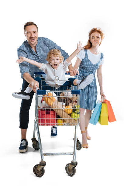 kuvapankkikuvat ja rojaltivapaat kuvat aiheesta onnelliset nuoret vanhemmat paperipusseilla, jotka kantavat iloista pientä poikaa istumassa ostoskärryssä - interior alaska