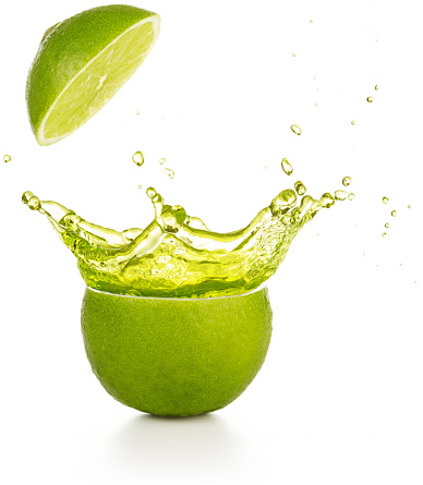 juice spraying out of a lime isolated on white