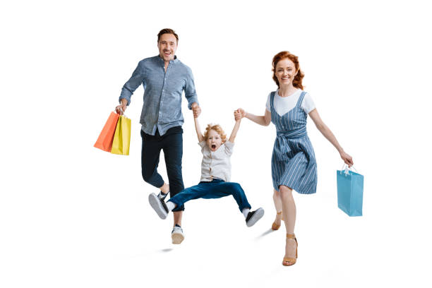 kuvapankkikuvat ja rojaltivapaat kuvat aiheesta onnellinen nuori perhe, jolla on yksi lapsi pitelemässä ostoskasseja ja hymyilemässä kameralle eristettynä valkoisella - interior alaska