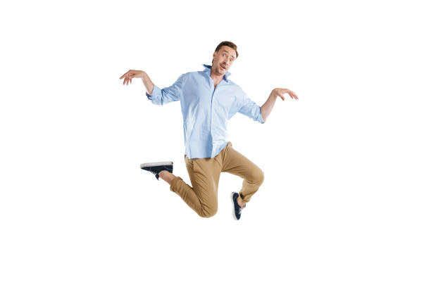 istock young casual man jumping with funny expression isolated on white 805269022