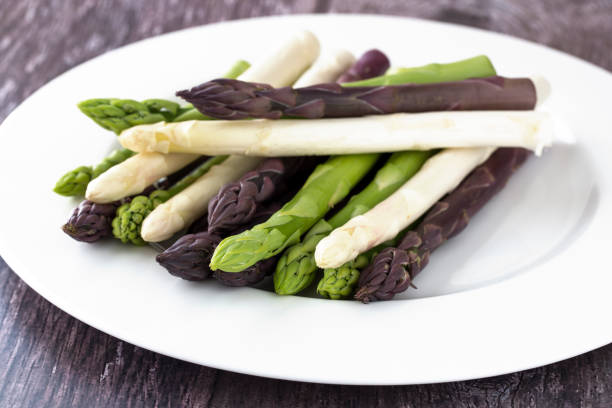 white, green and purple aspargus on white plate