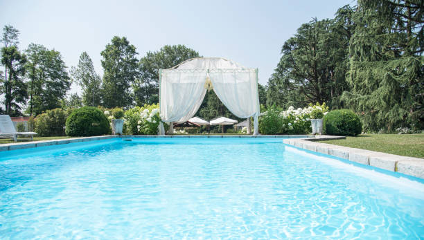 istock Wedding location - swimming pool and a gazebo with white curtains 805291162