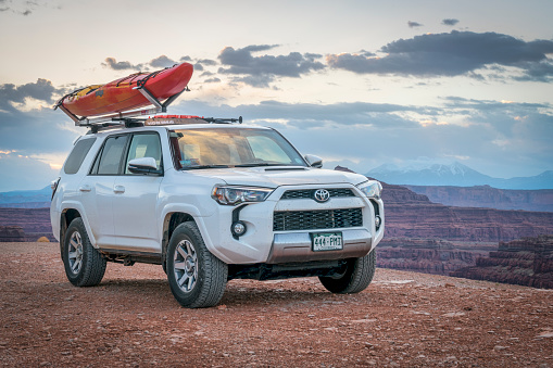 Potash , Ut: Toyota 4runner SUV (2016 trail edition) with a whitewater kayak on roof racks in the Colorado RIver canyoin near Moab.