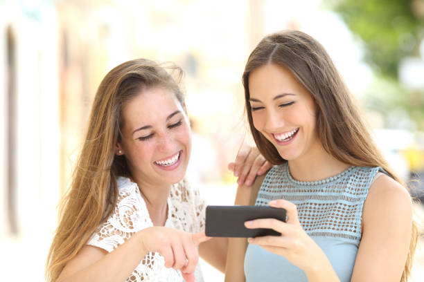 istock Two friends watching media content in a smart phone 805298630