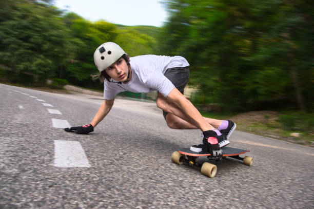 A detailed close-up of a person's foot in a black sneaker pushing off the ground while riding a skateboard on a red running track