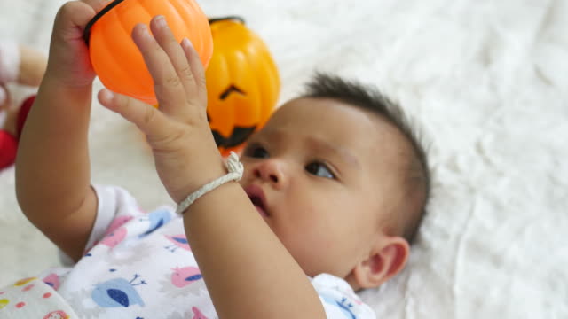 Asian baby smiling with pumpkin toy