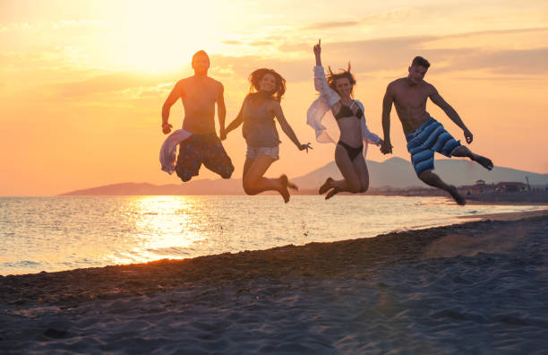 istock Happy young people jumping on the beach. 805353586
