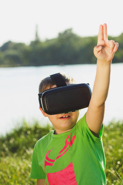 istock Boy plays game with virtual reality glasses outdoors 805378346